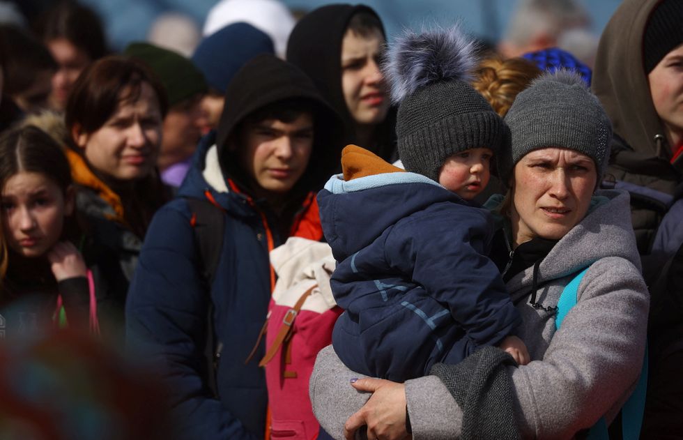 Refugees queue for buses taking them to safe places outside Ukraine as they flee the ongoing Russian invasion, outside the main train station in Lviv, Ukraine, March 12, 2022.  REUTERS/Kai Pfaffenbach