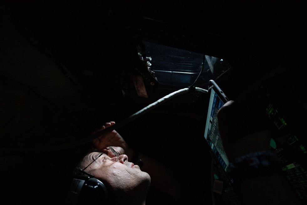 Reid Wiseman peers out of the Orion module over the Moon