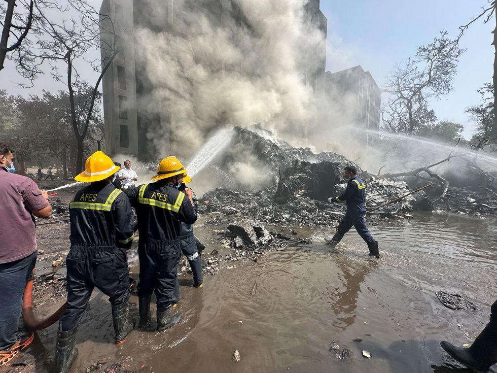 Rescue team members work as smoke rises at the site where an Air India plane crashed\u200b
