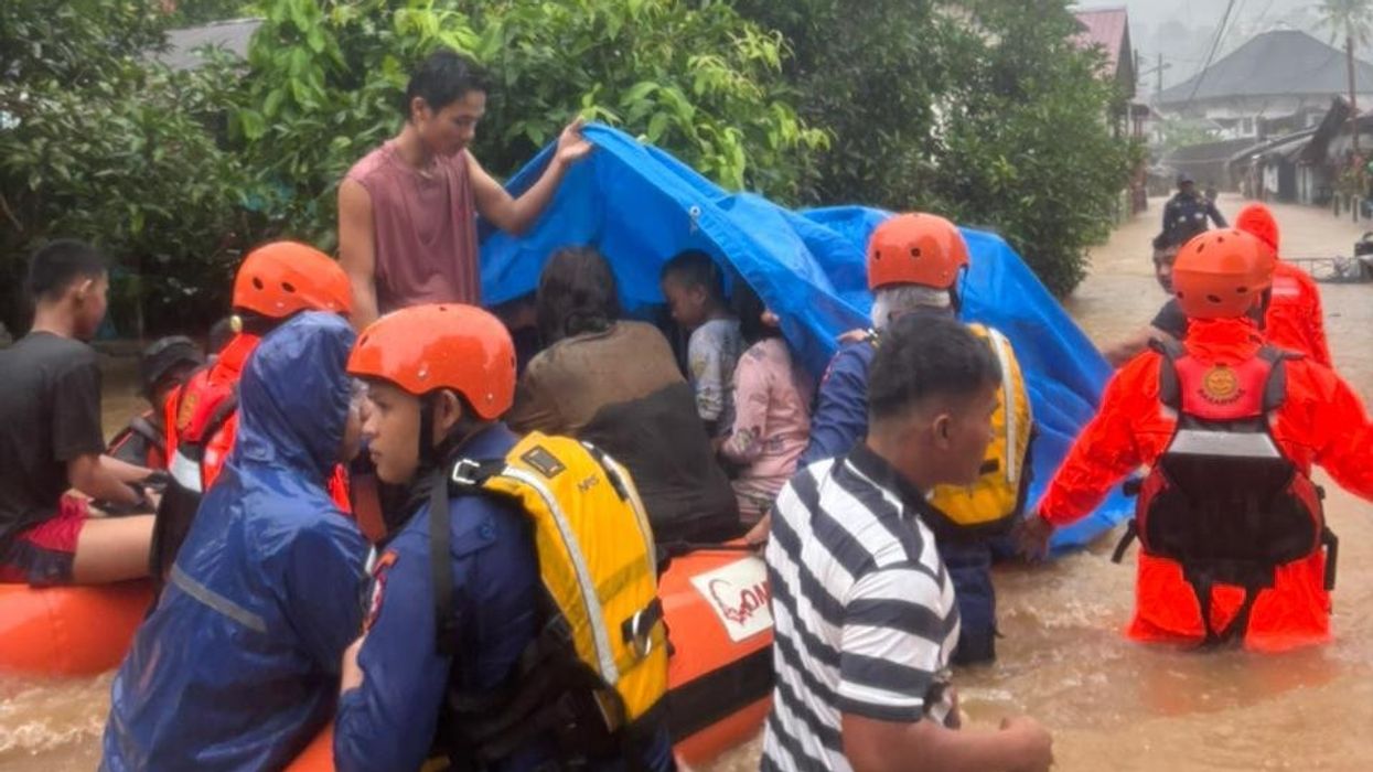 Rescue workers on Sumatra evecuate people displaced by the floods