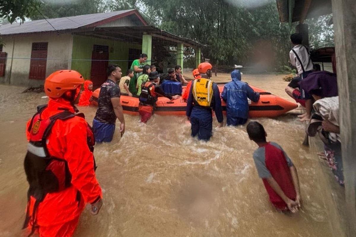 Rescue workers on Sumatra evecuate people displaced by the floods