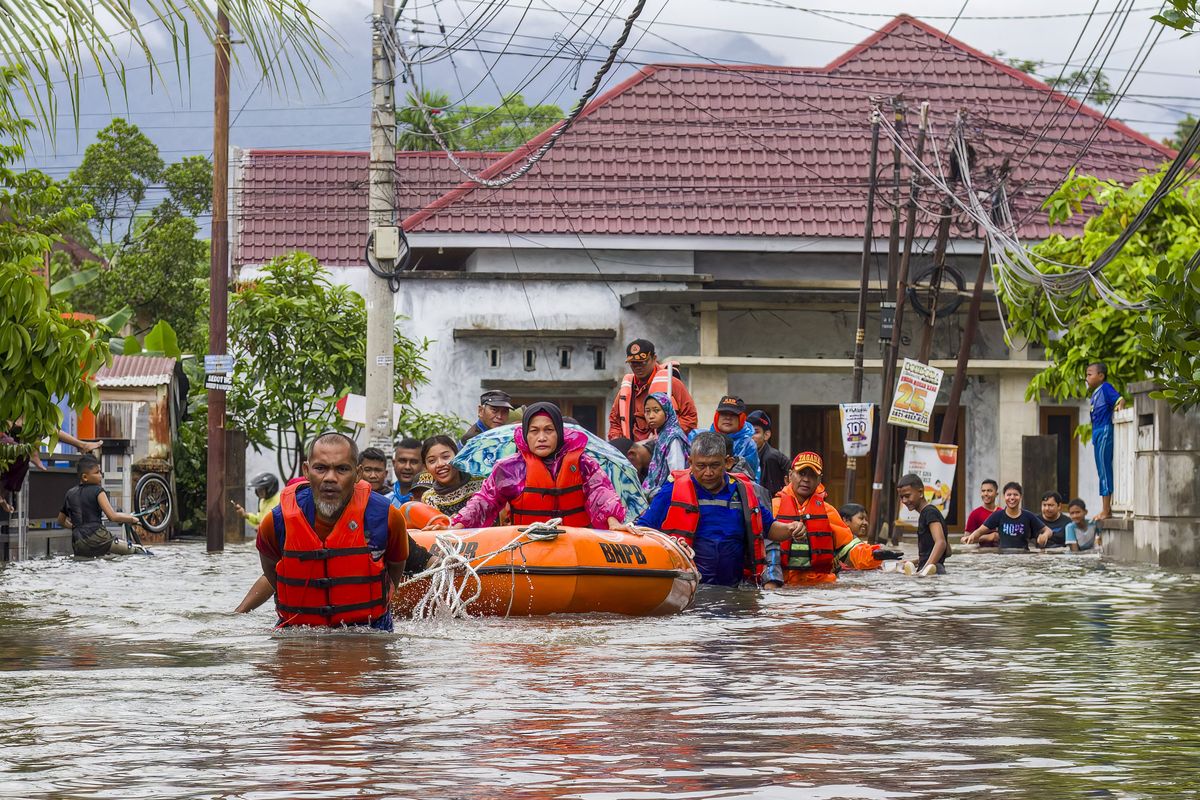 Rescue workers on Sumatra evecuate people displaced by the floods