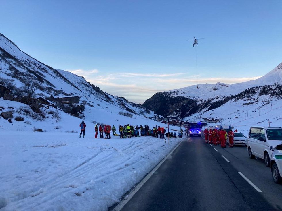 Rescue workers stand near the site where an avalanche buried 10 skiers in the Lech/Zuers free skiing area on Arlberg, Austria