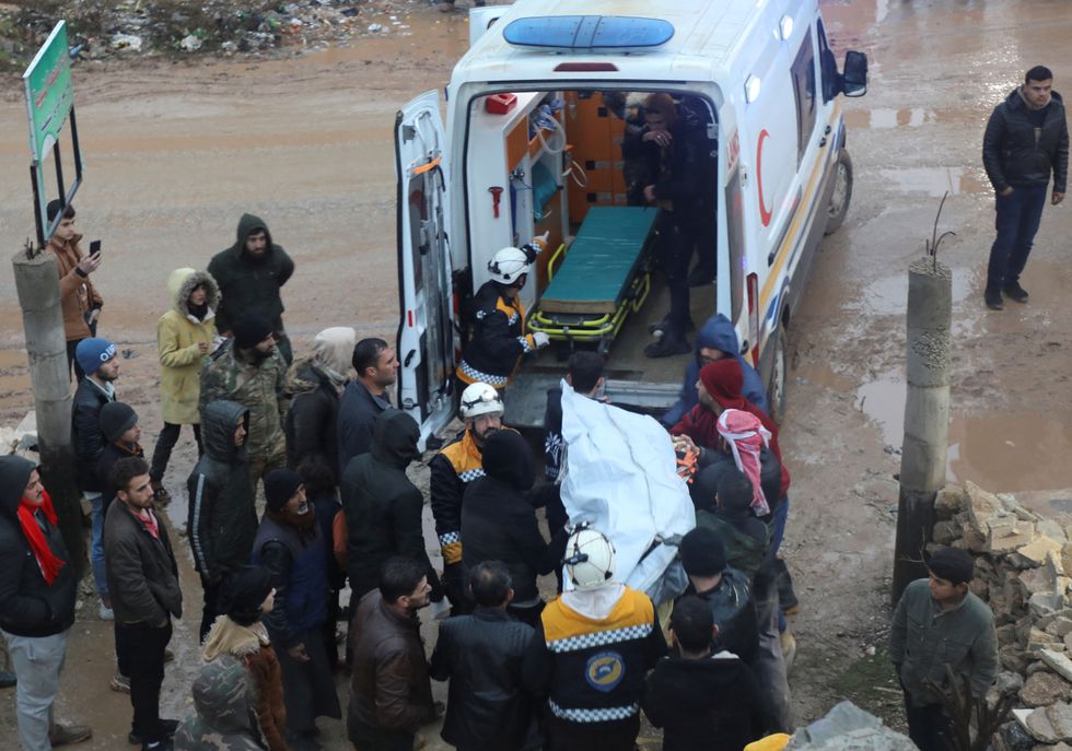 Rescuers carry a casualty into an ambulance at the site of a damaged building, following an earthquake, in rebel-held Azaz, Syria February 6, 2023. REUTERS/Mahmoud Hassano