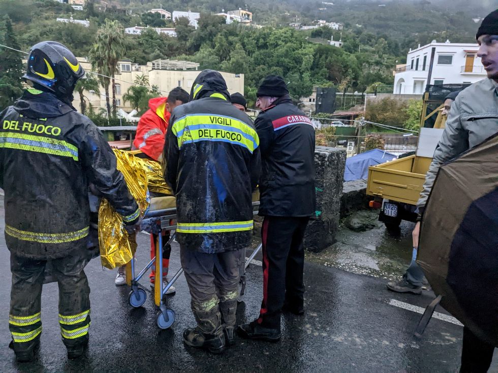 Rescuers help an injured person following a landslide on the Italian holiday island of Ischia, Italy, in this handout photo obtained by Reuters on November 26, 2022. Carabinieri/Handout via REUTERS THIS IMAGE HAS BEEN SUPPLIED BY A THIRD PARTY.