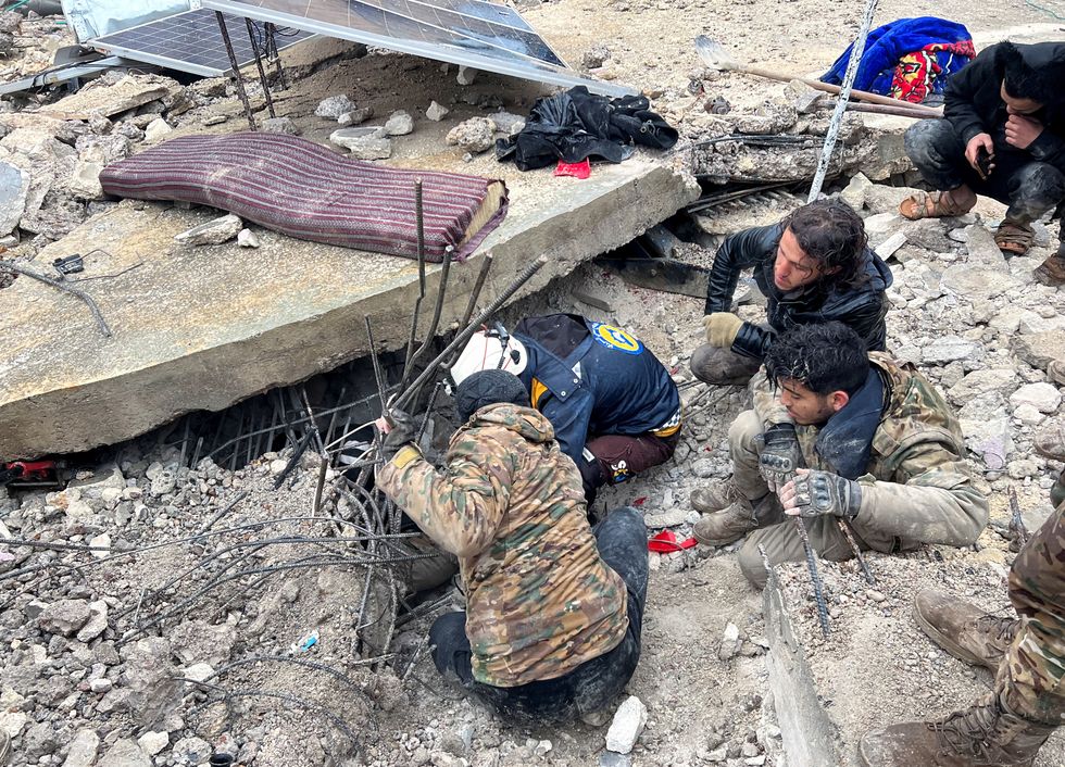 Rescuers search for survivors under the rubble, following an earthquake, in rebel-held town of Jandaris, Syria