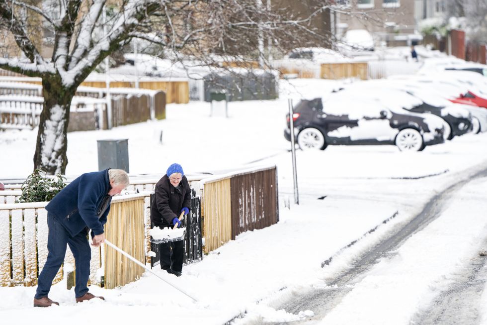 Residents clear snow from the street in California near Falkirk as Storm Eunice sweeps across the UK after hitting the south coast earlier on Friday. With attractions closing, travel disruption and a major incident declared in some areas, people have been urged to stay indoors. Picture date: Friday February 18, 2022.