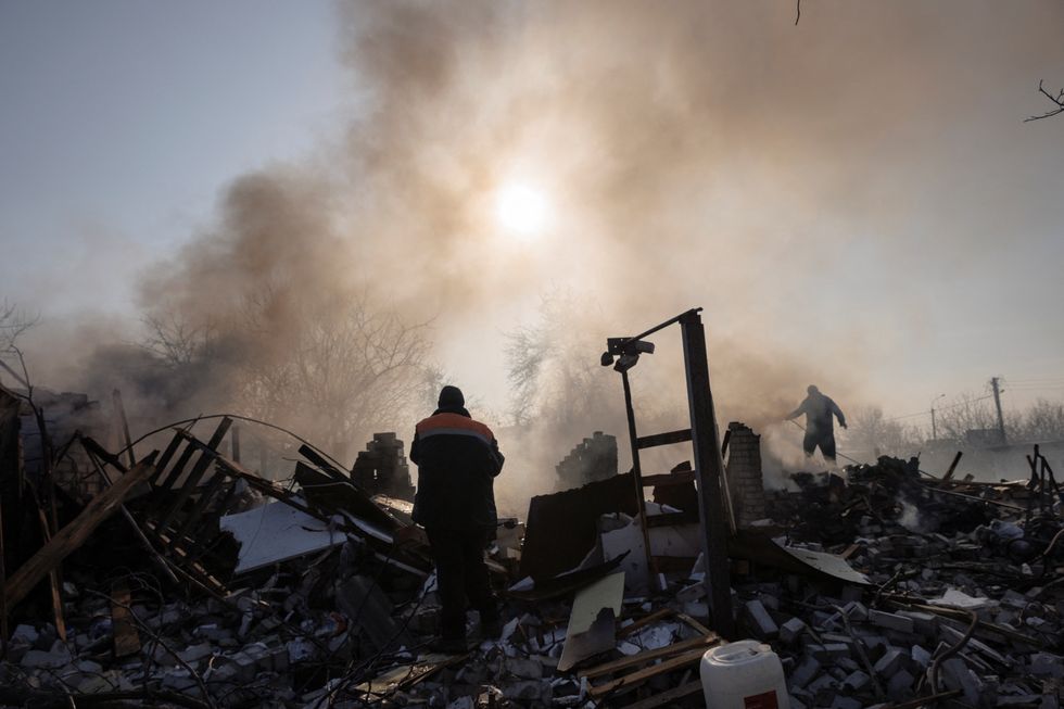 Residents extinguish a fire after a bombing destroyed a family home in a northern district of Kharkiv as Russia's attack on Ukraine continues, Ukraine, March 24, 2022.  REUTERS/Thomas Peter