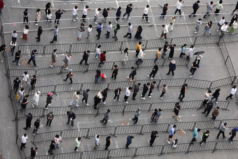 Residents line up at a makeshift nucleic acid testing site during a mass testing for the coronavirus disease (COVID-19) following the outbreak, in Beijing, China April 25, 2022. REUTERS/Tingshu Wang REFILE-QUALITY REPEAT