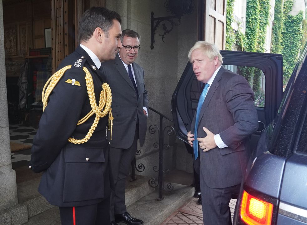 RETRANSMITTING ADDING NAMES Outgoing Prime Minister Boris Johnson is greeted by the Queen Elizabeth II's Equerry Lieutenant Colonel Tom White and her private Secretary Sir Edward Young as he arrives at Balmoral for an audience to formally resign as Prime Minister. Picture date: Tuesday September 6, 2022.