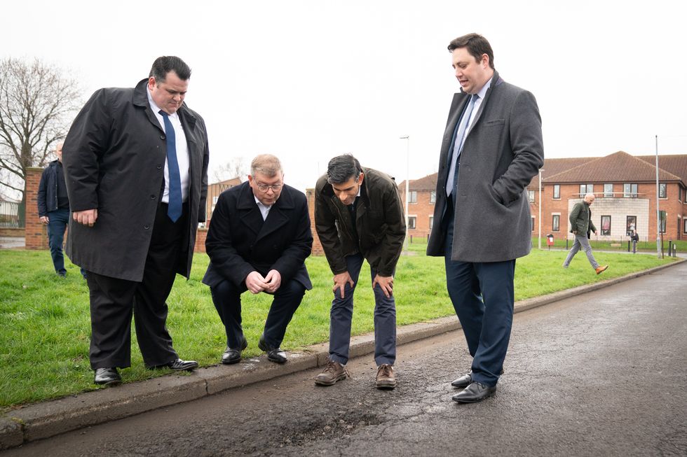 Rishi Sunak looking at a pothole