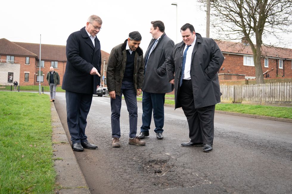Rishi Sunak looking at a pothole
