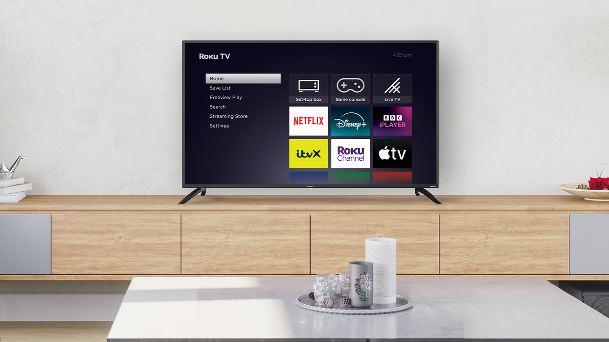 roku smart tv on a sideboard with candles on a small table