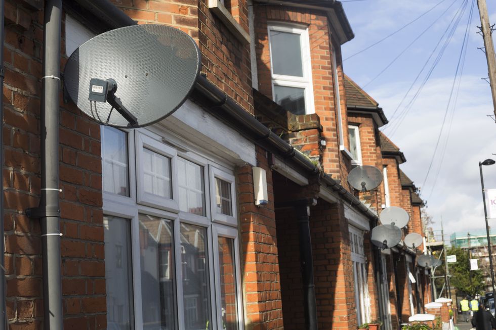row of terrace houses in the UK with satellite dishes on the outside