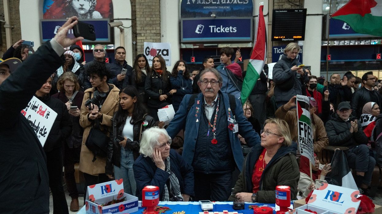 Royal British Legion poppy sellers look on as they are surrounded by people staging a sit-in inside Charing Cross train station during a pro-Palestinian demonstration