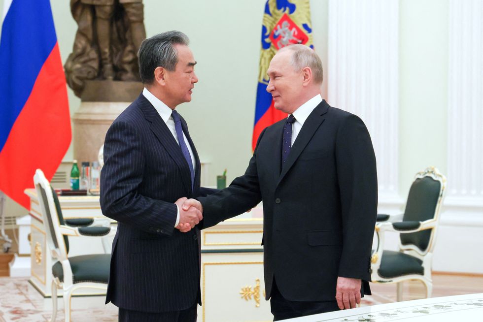 Russia's President Vladimir Putin shakes hands with China's Director of the Office of the Central Foreign Affairs Commission Wang Yi during a meeting in Moscow, Russia February 22, 2023. Sputnik/Anton Novoderezhkin/Pool via REUTERS ATTENTION EDITORS - THIS IMAGE WAS PROVIDED BY A THIRD PARTY.