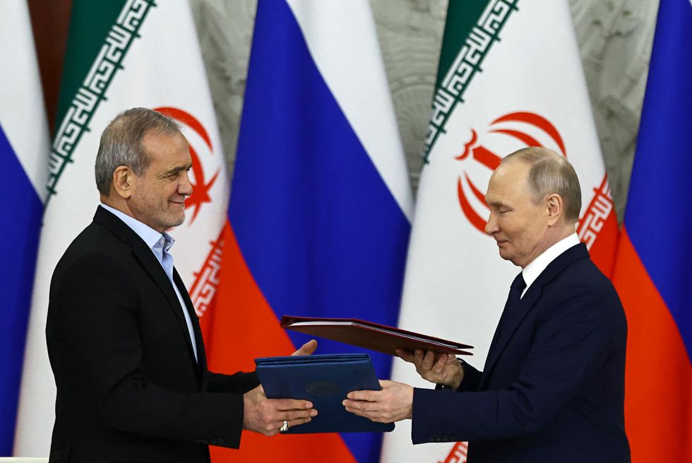 Russian President Vladimir Putin and Iranian President Masoud Pezeshkian sign a strategic partnership treaty during a ceremony following their talks at the Kremlin in Moscow