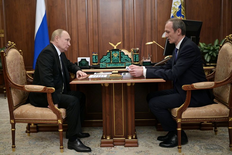 Russian President Vladimir Putin listens to Deputy Prime Minister Dmitry Grigorenko during a meeting.