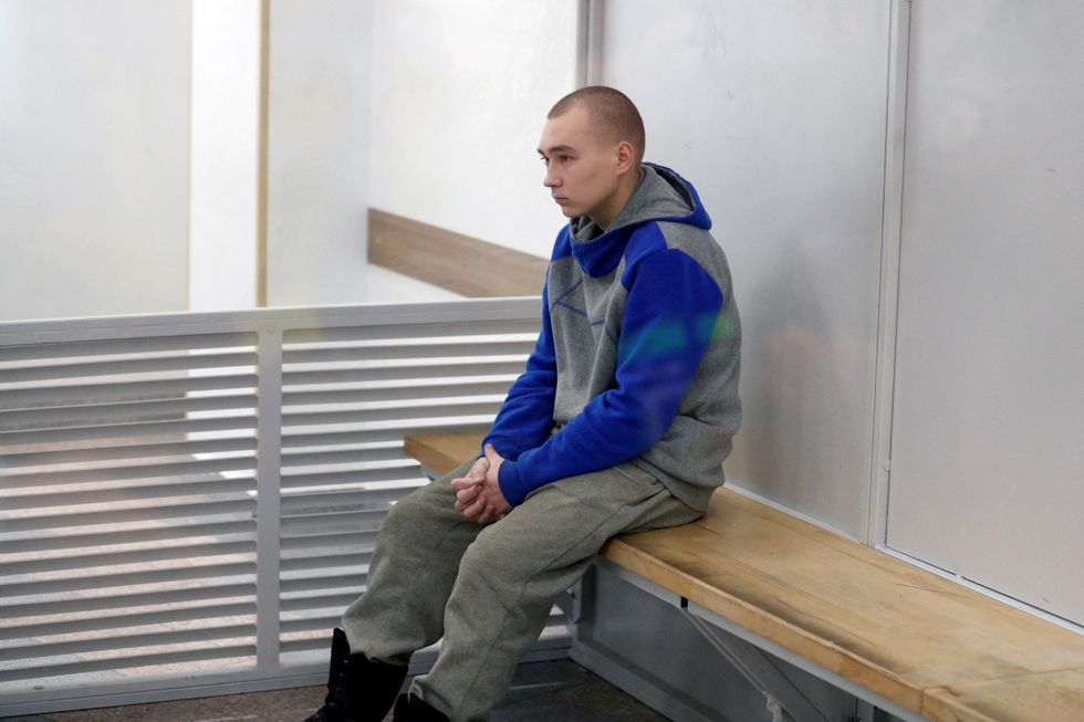 Russian soldier Vadim Shishimarin, 21, suspected of violations of the laws and norms of war, sits inside a cage during a court hearing, amid Russia's invasion of Ukraine, in Kyiv, Ukraine May 23, 2022. REUTERS/Viacheslav Ratynskyi