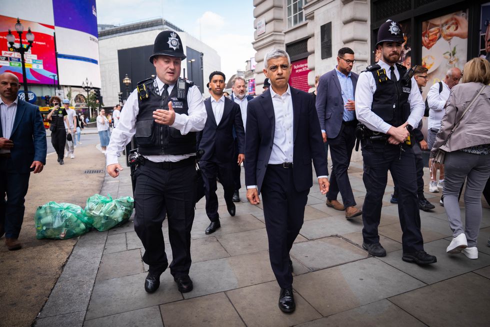 Sadiq Khan walking with police officers in Picadilly