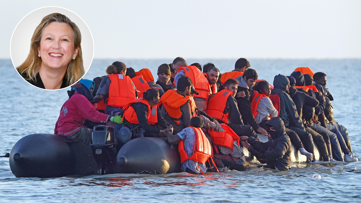 Sally-Ann Hart and A group of people thought to be migrants wade through the sea to clamber aboard a small boat off the beach in Gravelines, France