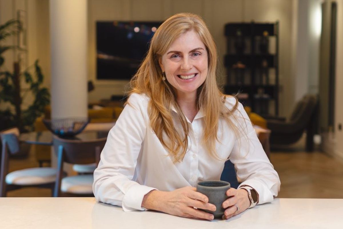 ​Samsung Chief Customer Officer Deborah Honig sits at a desk with a mug  
