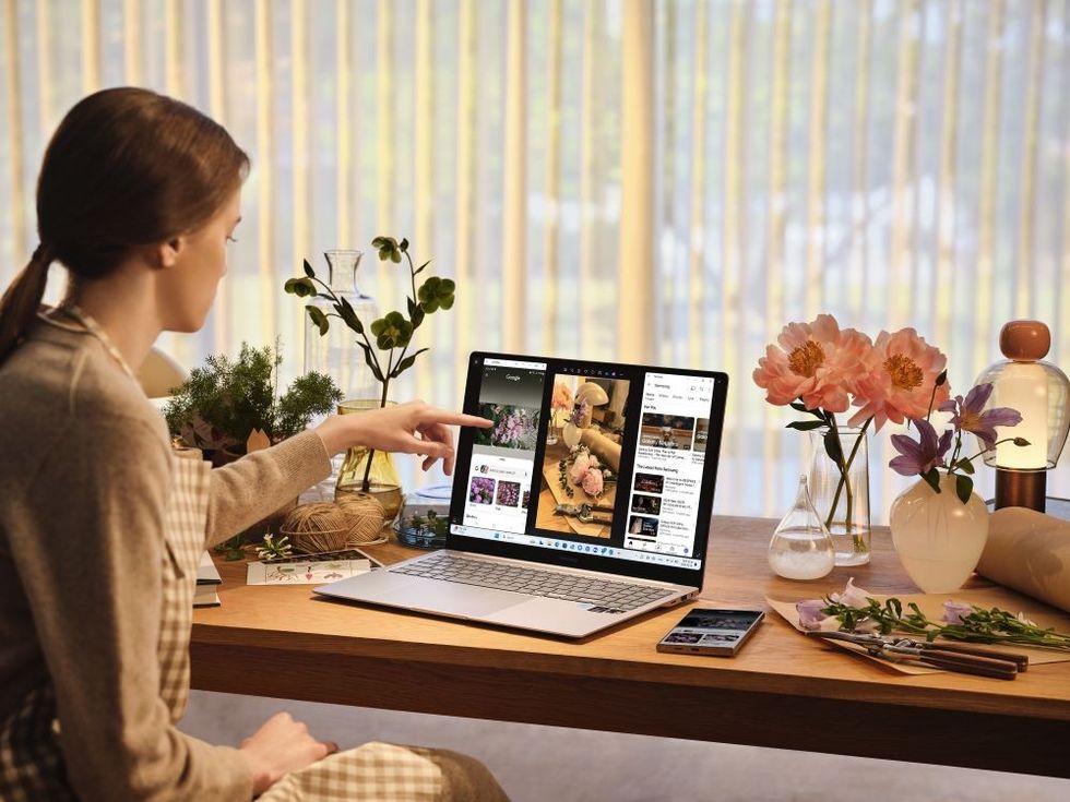 samsung galaxy book 4 edge laptop on a desk with a woman using the touchscreen