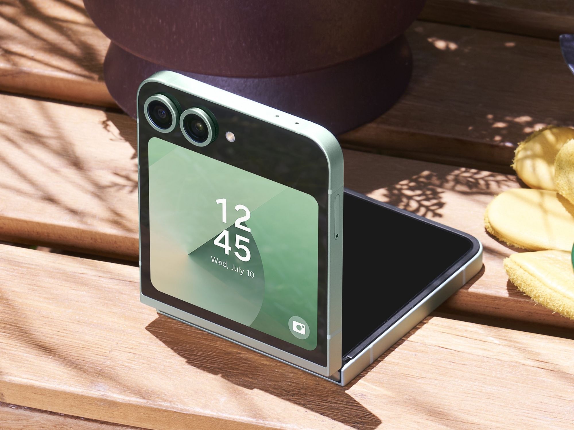 samsung galaxy z flip 6 in mint colour option pictured half-open on a wooden bench