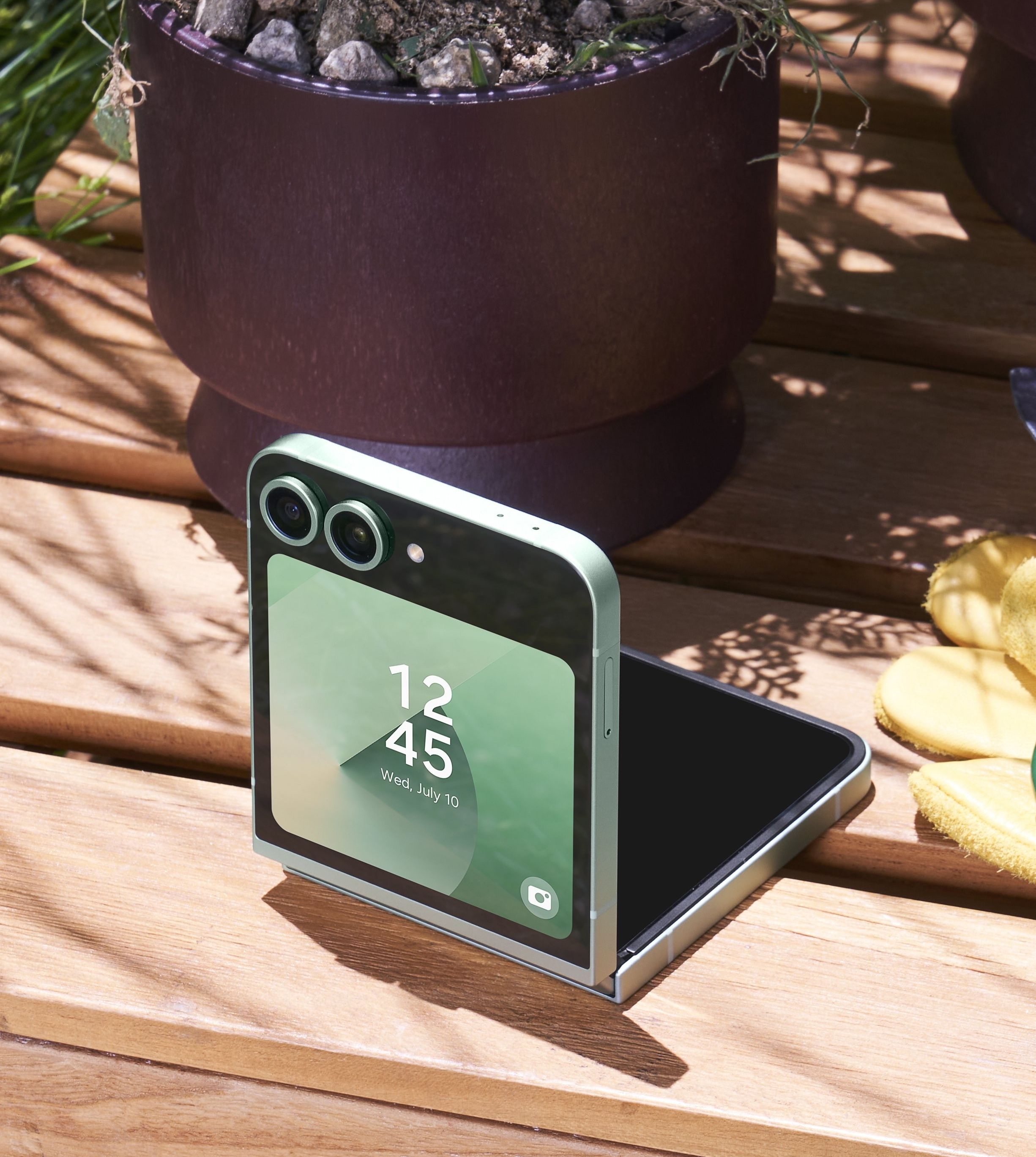 samsung galaxy z flip 6 in mint colour option pictured half-open on a wooden bench