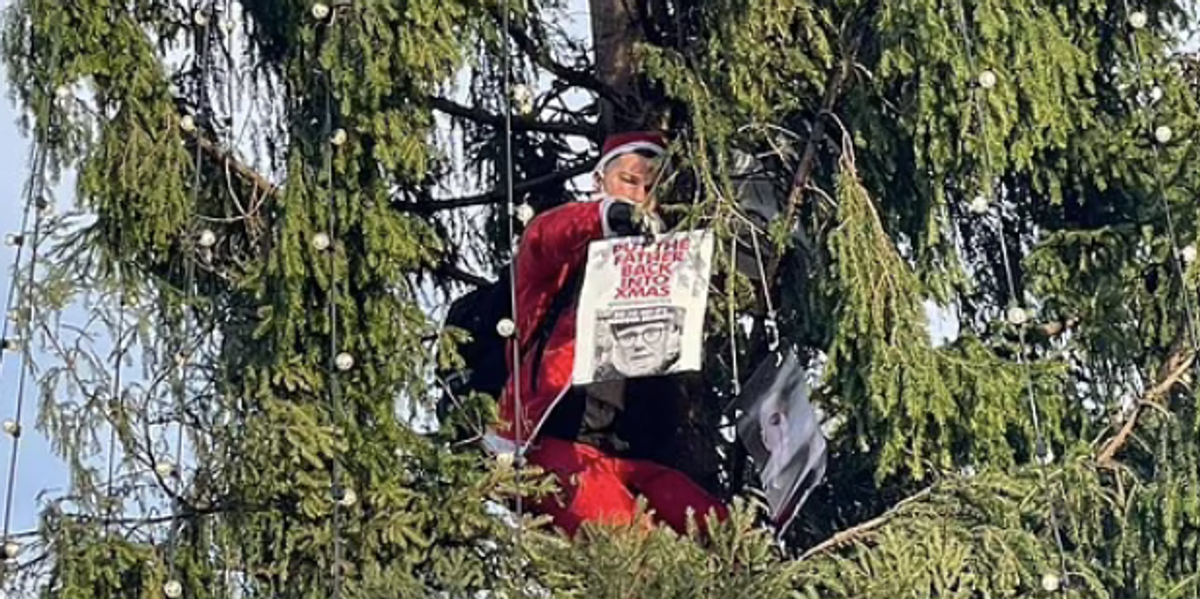 NextImg:Man dressed as Santa climbs Christmas tree in Trafalgar Square with message for Keir Starmer
