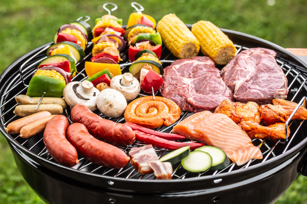 Sausages, vegetable kebabs and steaks on barbecue