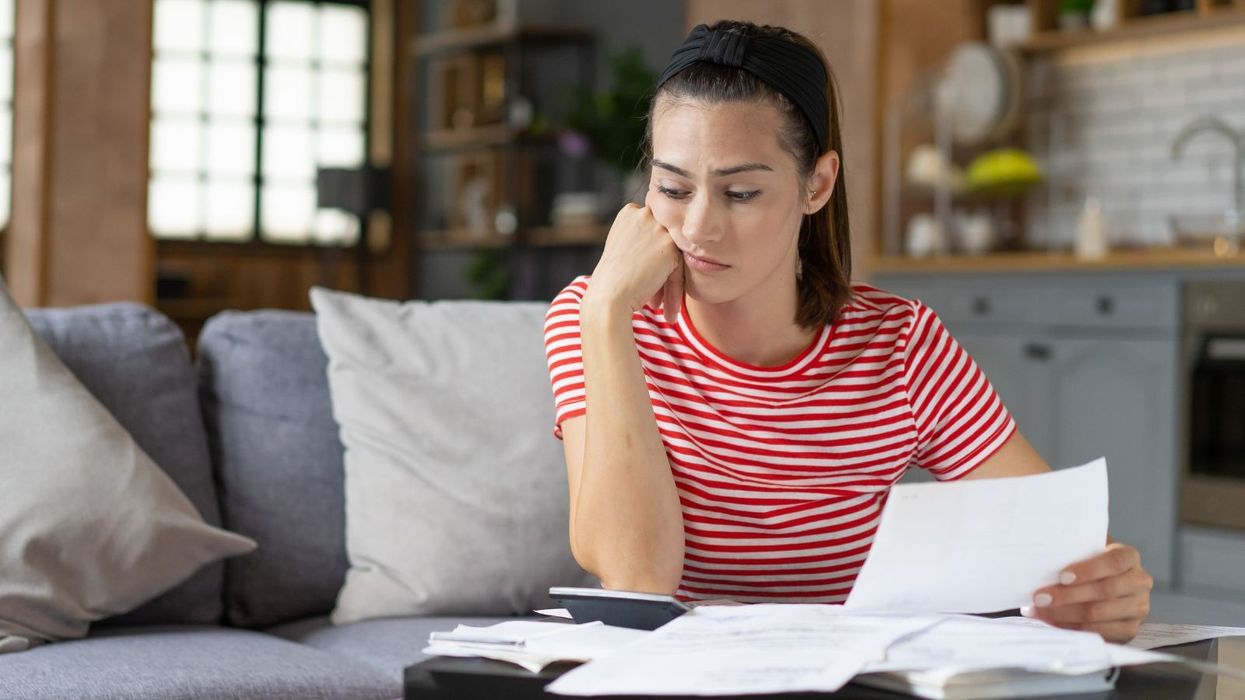 Saver looks at calculator and bank statement