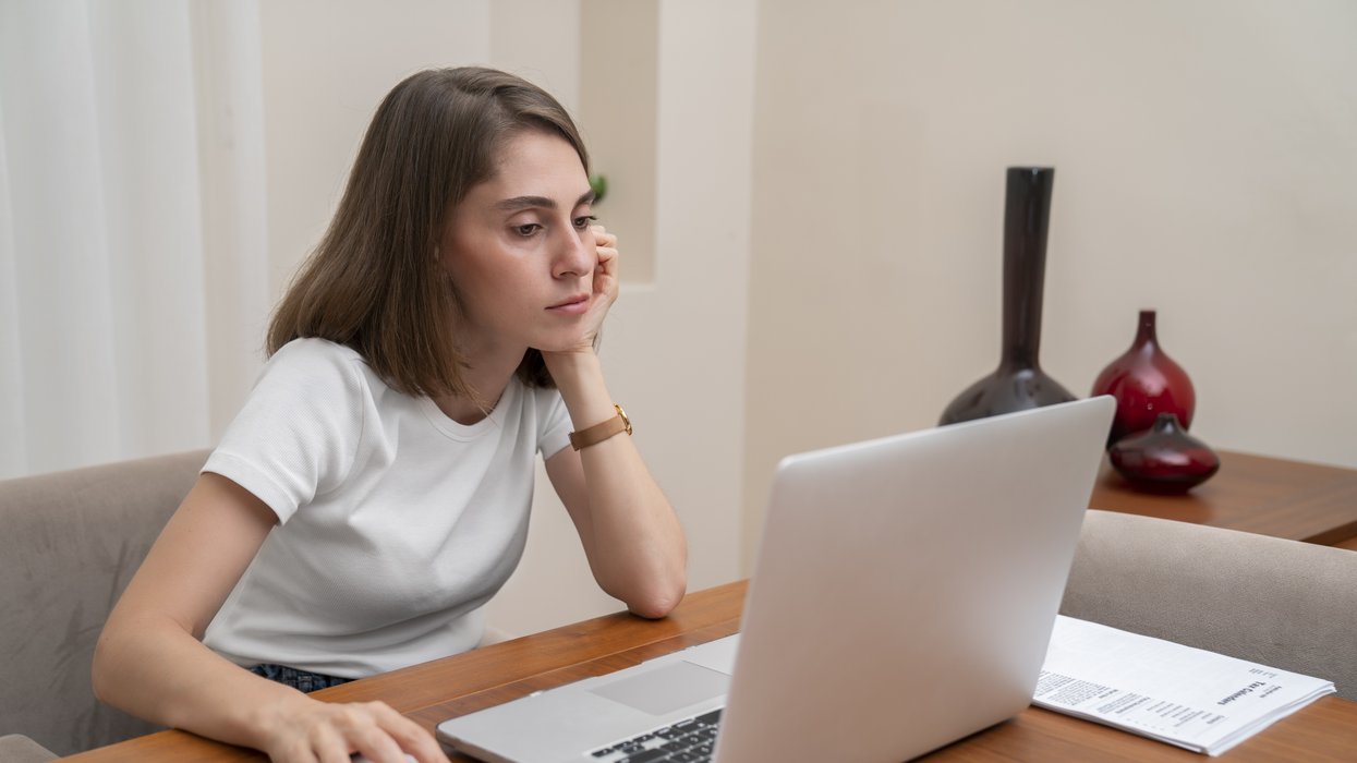 Saver looks worried at laptop