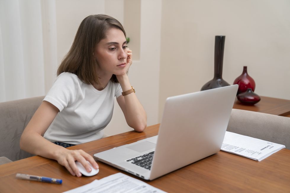Saver looks worried at laptop