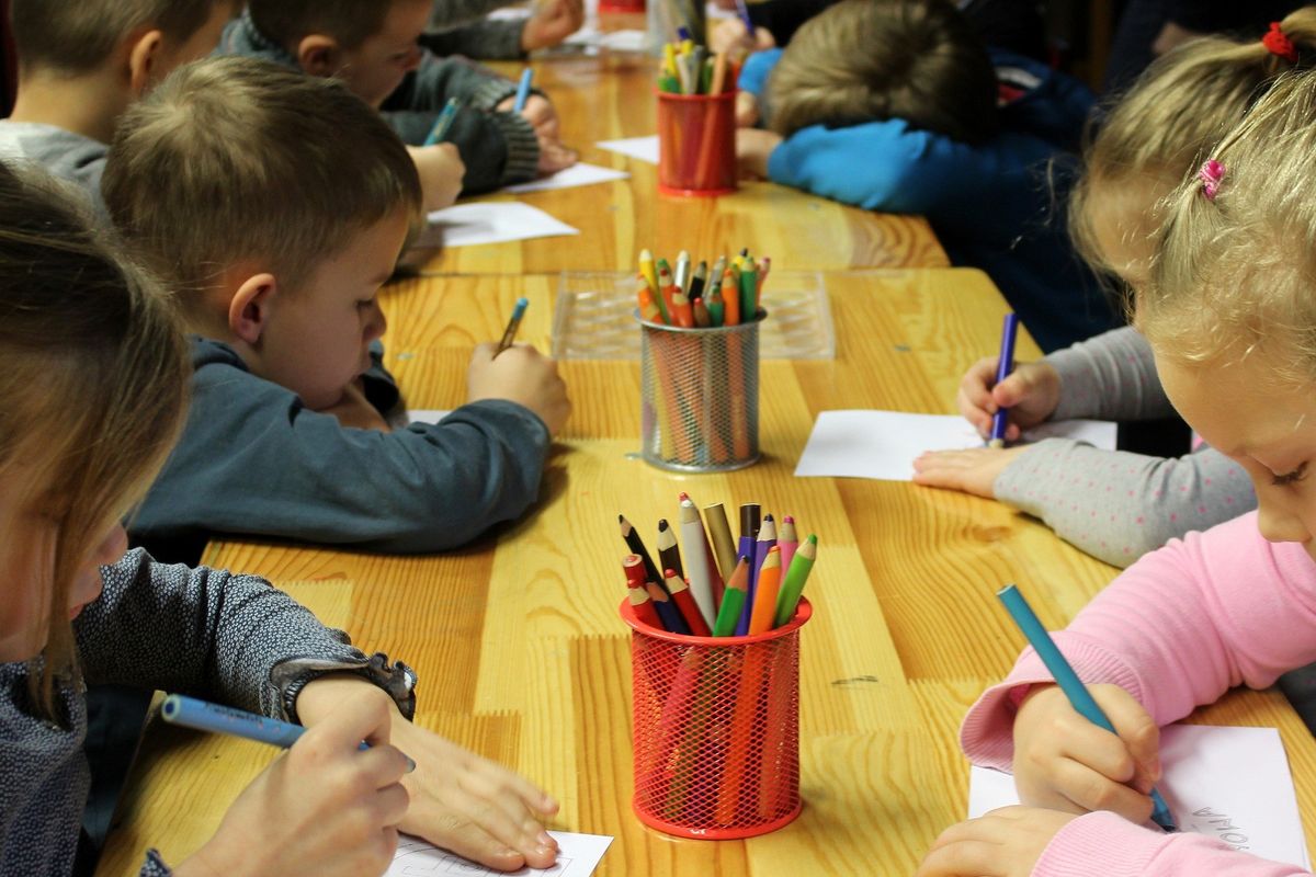 School children colouring on paper