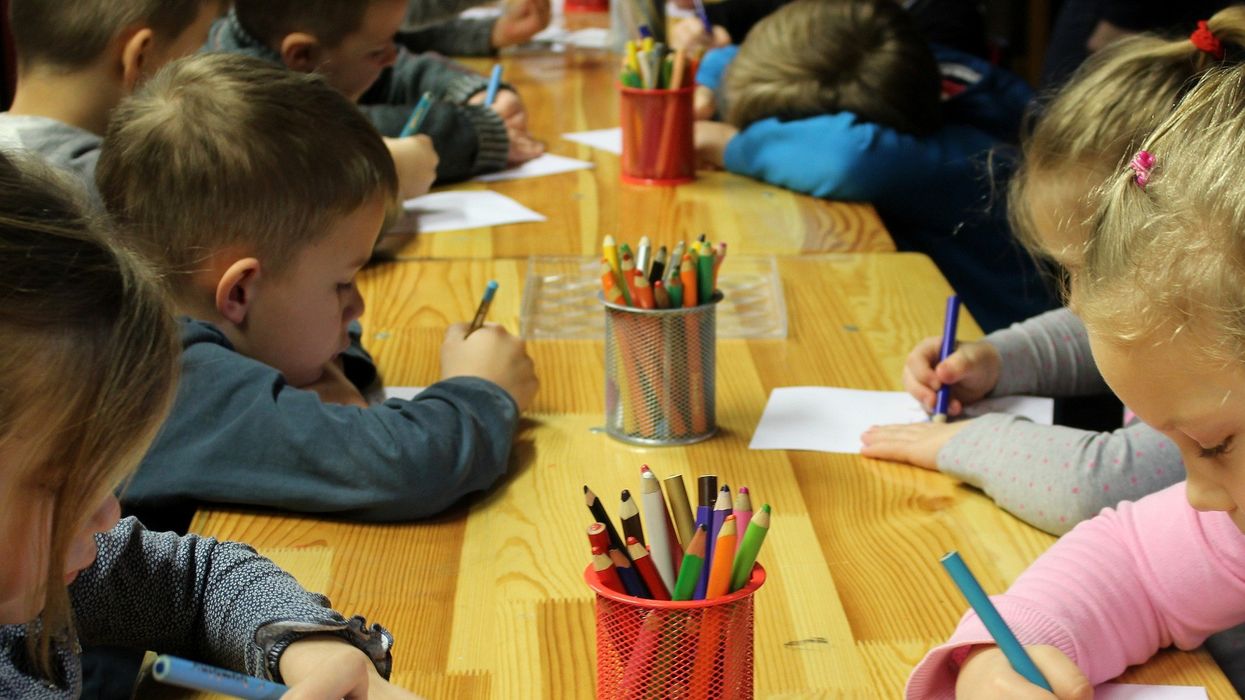 School children colouring on paper