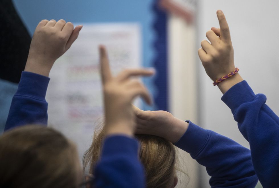 School children with their hands up