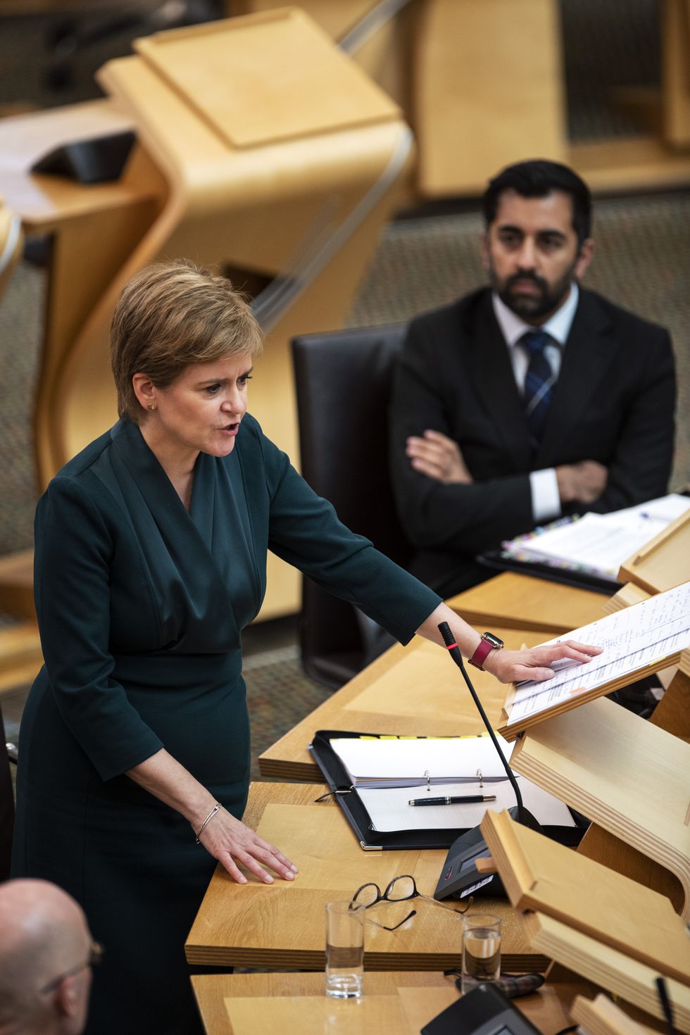 Scotland's First Minister Nicola Sturgeon, watched by Humza Yousaf, Cabinet Secretary for Health and Social Care.