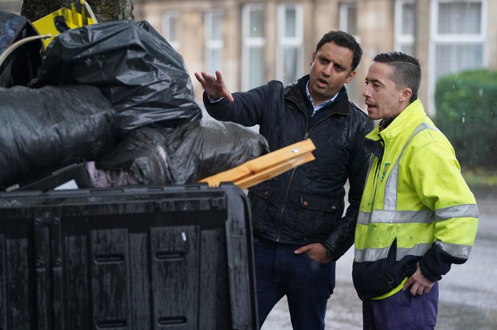 Scottish Labour leader Anas Sarwar is shown an overflowing bin by Barry McAreavey as he meets GMB cleansing workers in Glasgow to learn about their dispute with the Scottish Government ahead of Cop26.