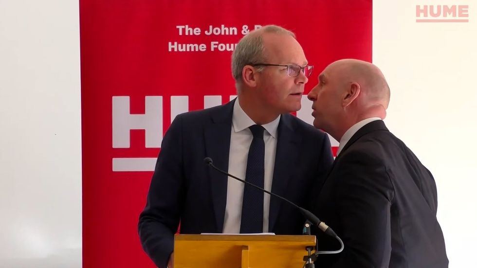 Screengrab taken from video issued by the Hume Foundation of Irish Foreign Affairs Minister, Simon Coveney, being ushered from the room due to a security alert whilst he was speaking at a peacebuilding event organised by the John and Pat Hume Foundation at The Houben Centre, Belfast. Issue date: Friday March 25, 2022.