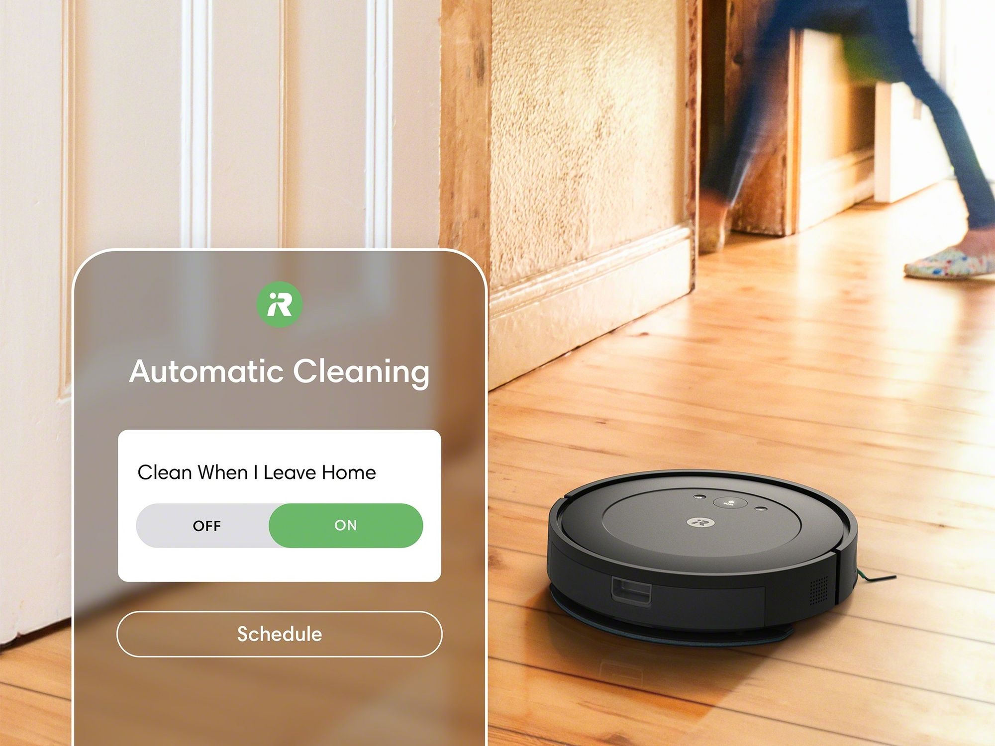 screenshot of the irobot app showing a cleaning schedule and the roomba mopping in the background