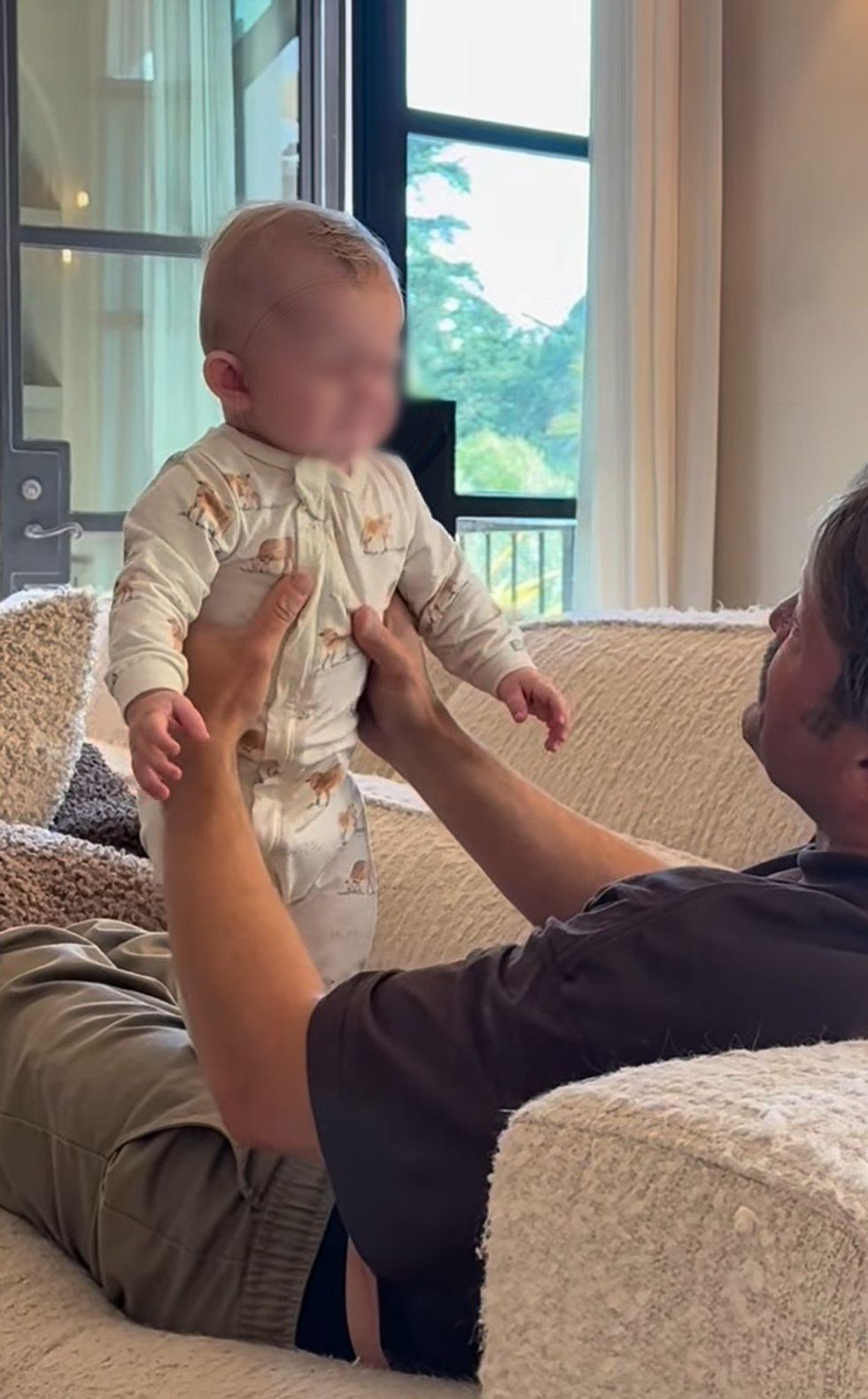 Screenshot shows Mr McAnally playing with the baby