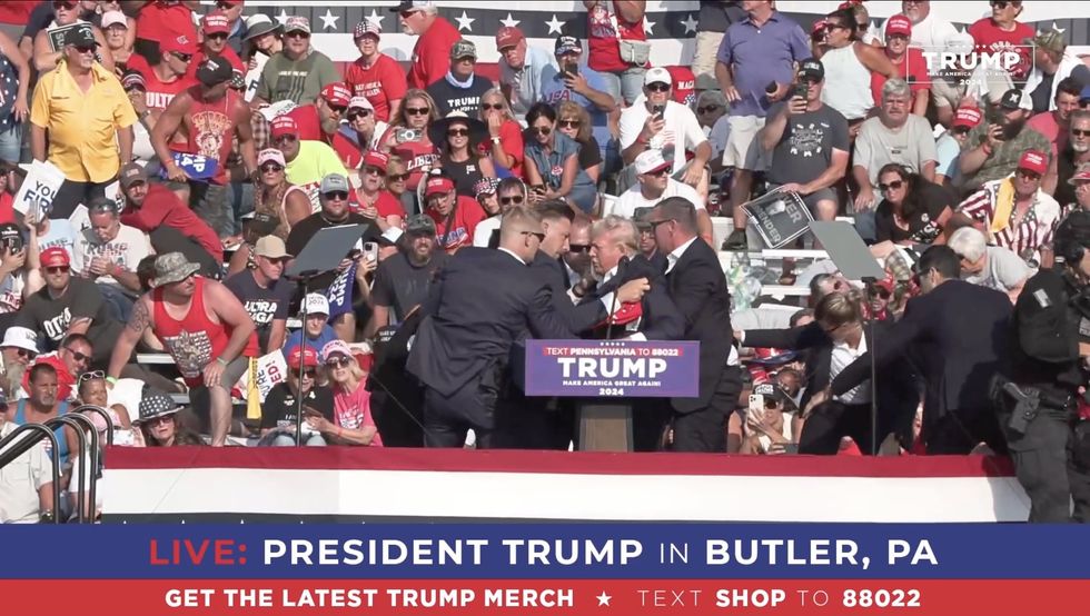 Secret Service surround Trump as they prepare to escort him off stage