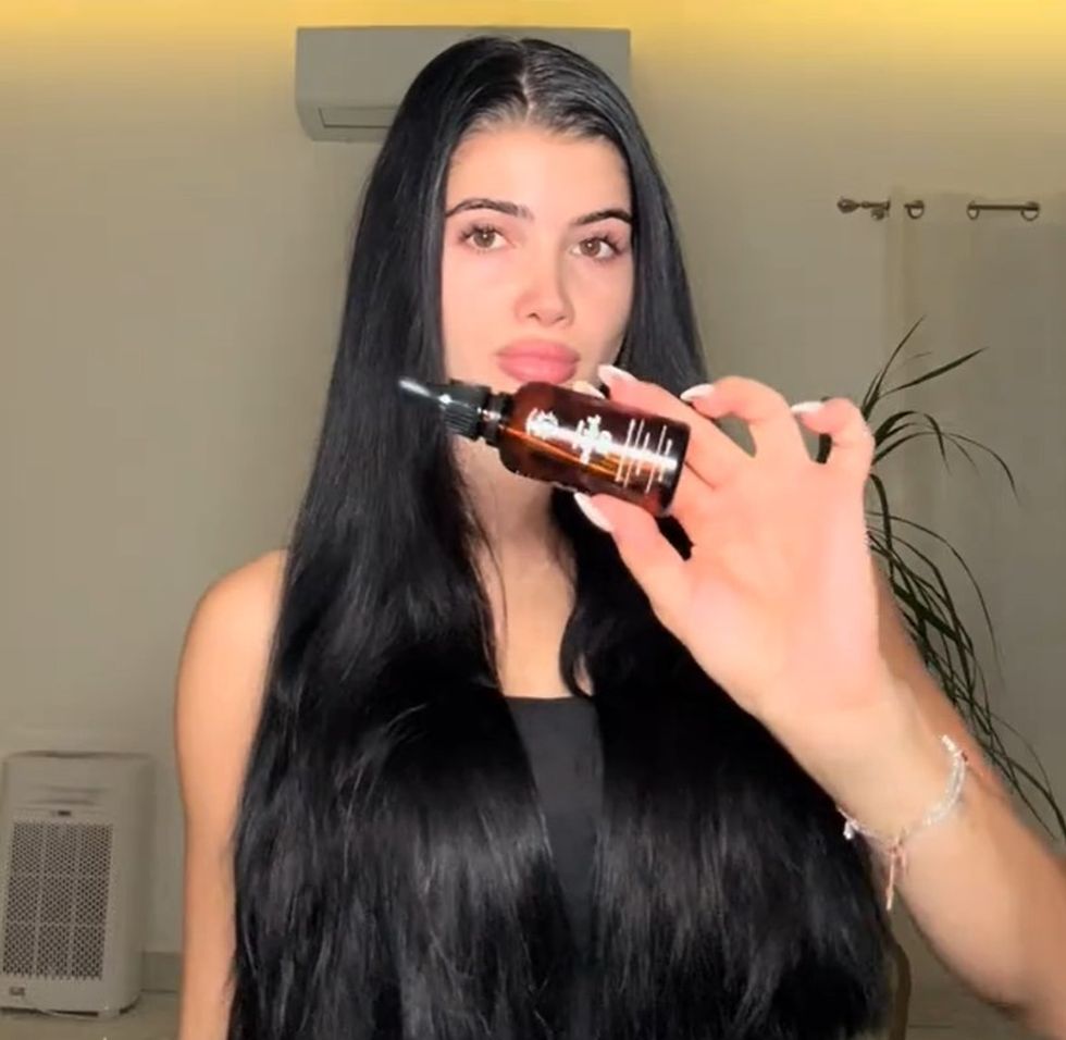 Selina holding up jojoba oil