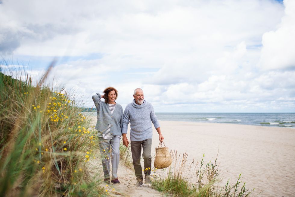 Senior couple walking along a sandy beach