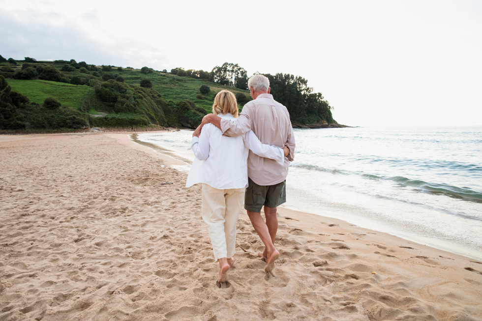 Senior couple walking along a sandy beach