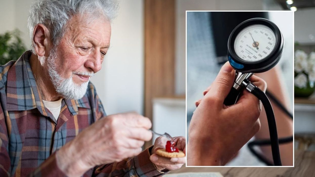 SENIOR MAN EATING AND BLOOD PRESSURE MONITOR