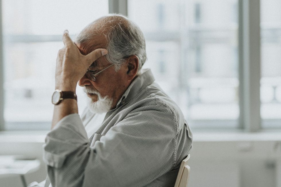 senior person holding head