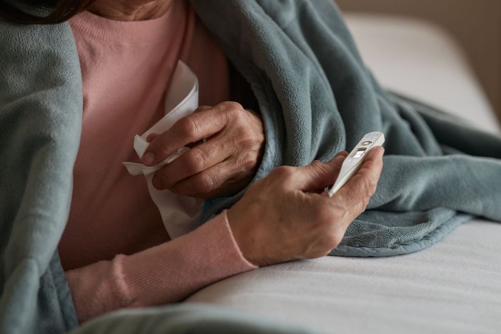 Senior person holding thermometer