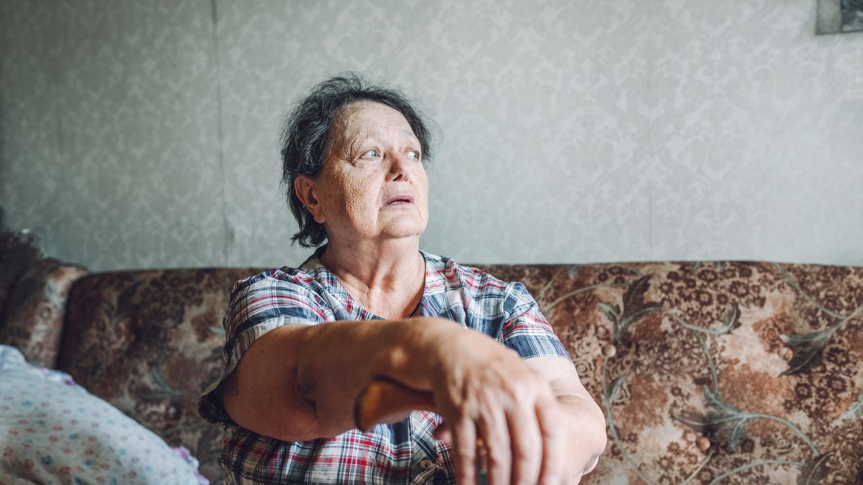 Senior person looking out window